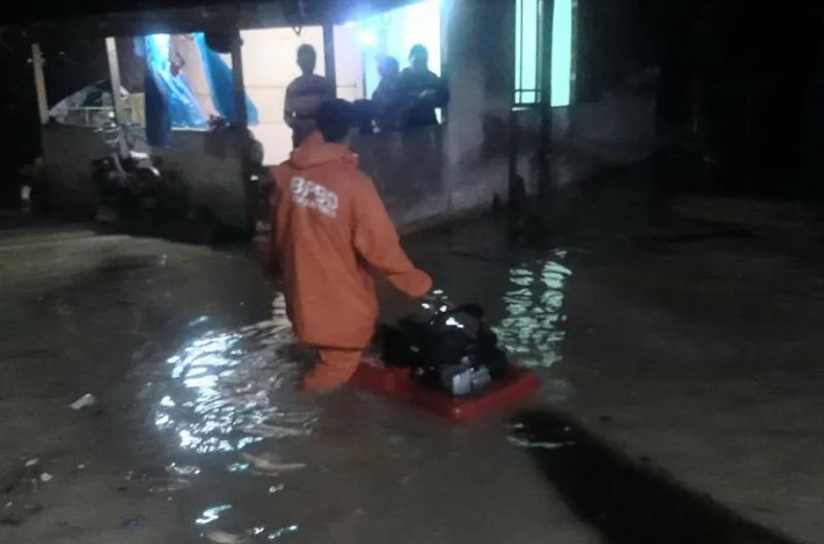Petugas BPBD Kota Bukittinggi, Sumatera Barat melakukan penyedotan air yang menggenangi perumahan warga akibat curah hujan tinggi disertai angin kencang yang terjadi pada Senin (27/03) malam. Libassonline.com